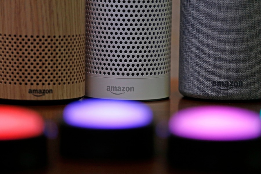 FILE - Amazon Echo and Echo Plus devices, behind, sit near illuminated Echo Button devices, Sept. 27, 2017, during an event announcing several new Amazon products by the company in Seattle. On Wednesday, Sept. 20, 2023, Amazon unveiled a slew of gadgets and an update to its popular voice assistant Alexa, infusing it with more generative AI features to better compete with other tech companies who've rolled out flashy chatbots.