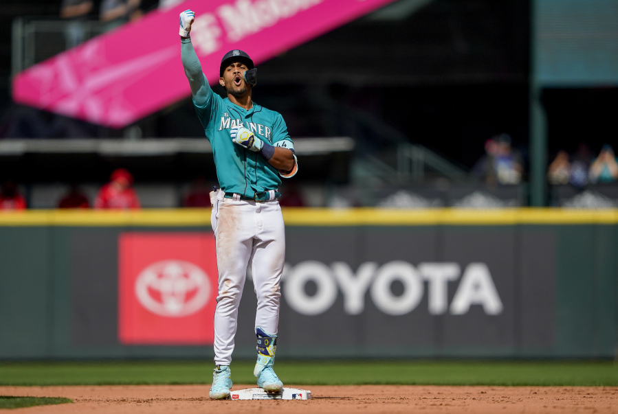 Seattle Mariners' Julio Rodriguez celebrates hitting an RBI double to score Josh Rojas against the Los Angeles Angels during the third inning of a baseball game Wednesday, Sept. 13, 2023, in Seattle.