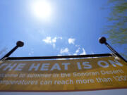 FILE - Patrons are warned about the heat at the Desert Botanical Garden entrance, Wednesday, Aug. 2, 2023, in Phoenix. America's hottest big metro is on track to set an annual record for heat-associated deaths after a sweltering Phoenix summer. (AP Photo/Ross D.
