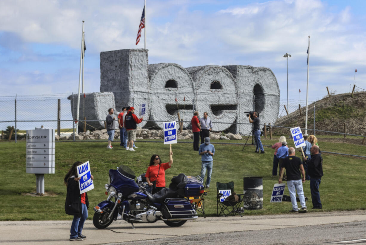 United Auto Workers hold signs while on strike Friday, Sept. 15, 2023, at the Stellantis Toledo Assembly Complex in Toledo, Ohio.