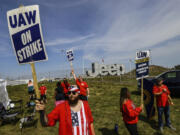 Matthew Gump, left, and other United Auto Workers walk the picket line during the auto workers strike Thursday, Sept. 21, 2023, at the Stellantis Toledo Assembly Complex in Toledo, Ohio.