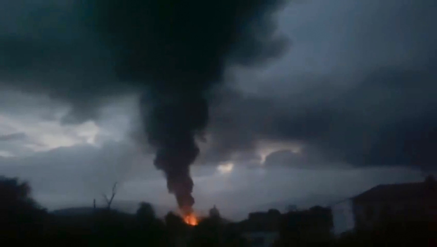 This grab taken from video distributed by Siranush Sargsyan's Twitter account on Monday, Sept. 25, 2023, shows smoke rising after a fuel depot explosion near Stepanakert, Nagorno-Karabakh. Several dozen people were injured on Monday night at a gas station just outside of the breakaway region's capital, Stepanakert, where a fuel tank exploded. Dozens of people were lining up at the gas station at the time to fuel their cars in order to move to Armenia.