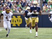 Notre Dame's Tobias Merriweather, right, secures a pass as he runs for a touchdown as Central Michigan's Donte Kent (4) chases him during the first half of an NCAA college football game on Saturday, Sept. 16, 2023, in South Bend, Ind.