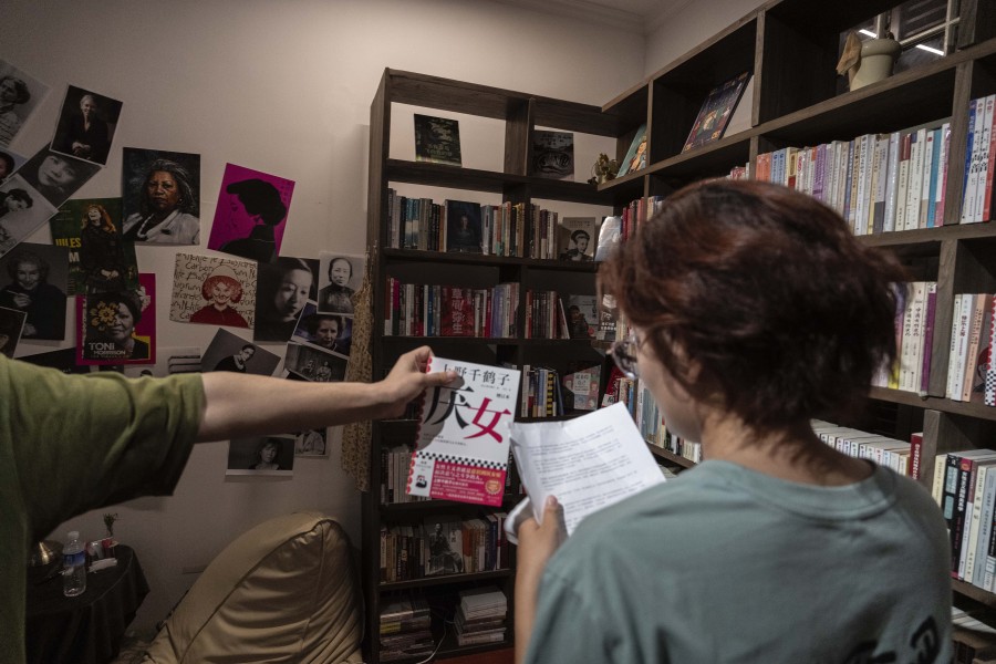 A bookstore worker hands over the book "Misogyny" written by Chizuko Ueno to Lu Sirui at a bookstore specialising in feminist literature in Beijing on Thursday, July 27, 2023. Like a growing number of Chinese women, Lu was inspired by this book in 2022 and became a feminist. From time to time, she would go back to Ueno's books to think about gender-based issues.