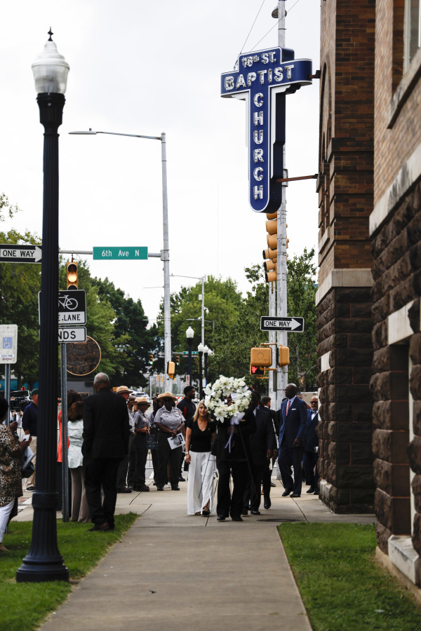 Friends and family members walk Friday with a wreath to lay at the site of the bombing during the 60th Commemoration of the 16th Street Baptist Church in Birmingham, Ala.