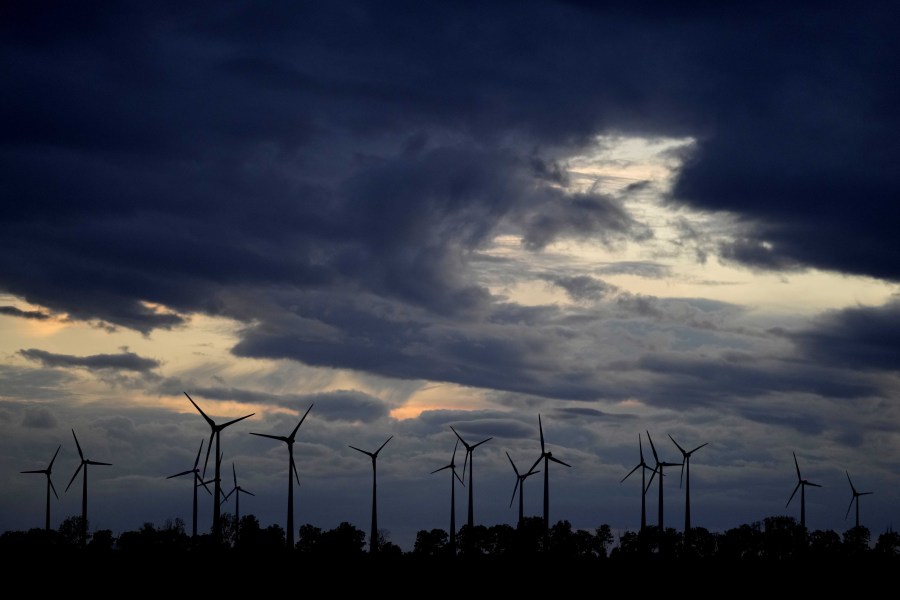 FILE - Wind turbines work at sunset on a wind farm near Aschersleben, Germany, July 23, 2023. Limiting global warming to 1.5 degrees Celsius (2.7 degrees Fahrenheit) is becoming harder but a narrow window remains because clean energy infrastructure has grown around the world, a new report said Tuesday, Sept. 26.