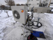 FILE - A condenser sits on the roof during the installation of a heat pump on Jan. 20, 2023, in Denver. A bipartisan coalition of about 25 governors and the Biden administration are set to announce a pledge Thursday, Sept. 21, 2023, to quadruple the number of heat pumps in U.S. homes by 2030.