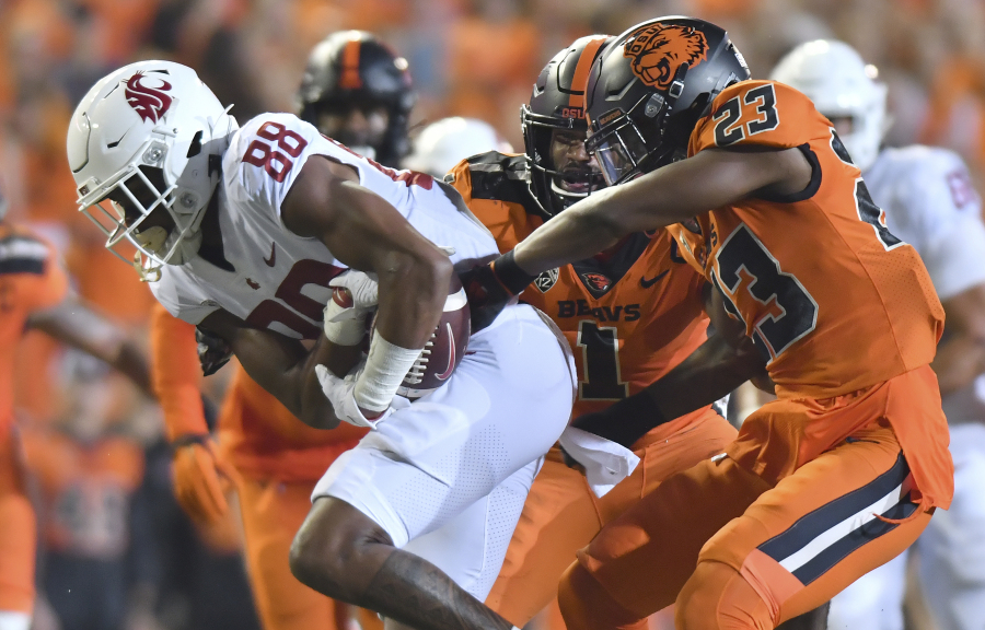 FILE - Oregon State's Ryan Cooper Jr. (23) attempts to strip the ball from Washington State's De'Zhaun Stribling (88) while Oregon State's Omar Speights (1) assists on the tackle during the first half of an NCAA college football game Saturday, Oct. 15, 2022, in Corvallis, Ore. Oregon State and Washington State are the last remaining members of the Pac-12 after this season and they have been fielding calls from the likes of the Mountain West and American Athletic conferences eager to discuss options.