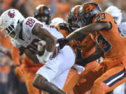 FILE - Oregon State's Ryan Cooper Jr. (23) attempts to strip the ball from Washington State's De'Zhaun Stribling (88) while Oregon State's Omar Speights (1) assists on the tackle during the first half of an NCAA college football game Saturday, Oct. 15, 2022, in Corvallis, Ore. Oregon State and Washington State are the last remaining members of the Pac-12 after this season and they have been fielding calls from the likes of the Mountain West and American Athletic conferences eager to discuss options.
