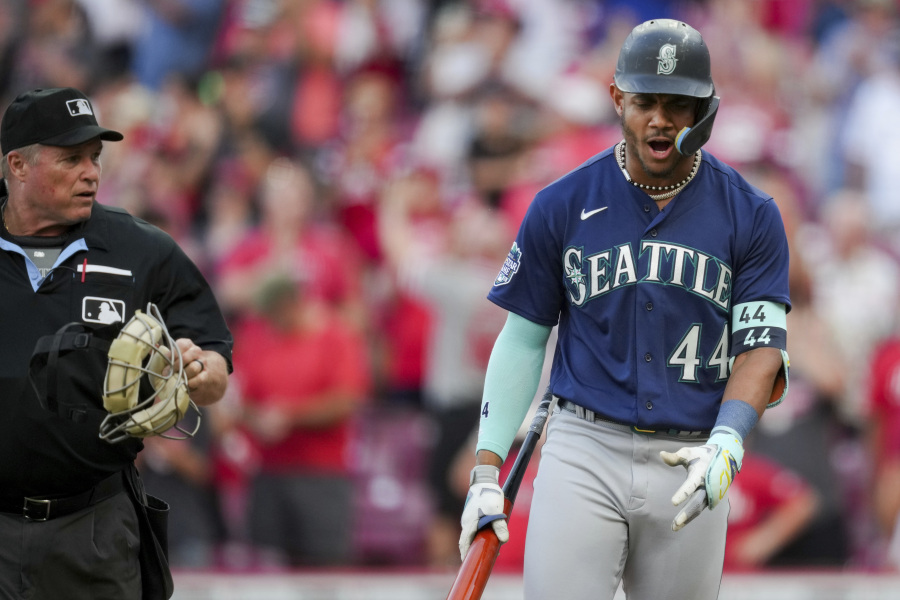Seattle Mariners' Julio Rodriguez, right, reacts to umpire Marvin Hudson, left, after striking out to end a baseball game against the Cincinnati Reds in Cincinnati, Monday, Sept. 4, 2023.