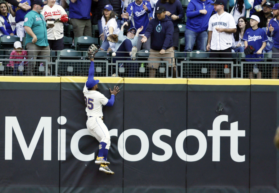 Seattle Mariners right fielder Teoscar Hernandez leaps but is unable to catch the home run ball hit by Los Angeles Dodgers' Jason Heyward during the first inning of a baseball game, Sunday, Sept. 17, 2023, in Seattle.