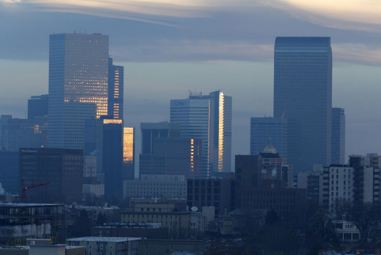 FILE - Pollution obscures the skyline of downtown as the sun rises over Denver, on Feb. 28, 2019. The Environmental Protection Agency is delaying plans to tighten air quality standards for ground-level ozone -- better known as smog -- despite a recommendation by a scientific advisory panel to lower air pollution limits to protect public health.