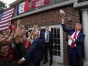 Former President Donald Trump throws a football to the crowd during a visit to the Alpha Gamma Rho, agricultural fraternity, at Iowa State University before an NCAA college football game between Iowa State and Iowa, Saturday, Sept. 9, 2023, in Ames, Iowa.