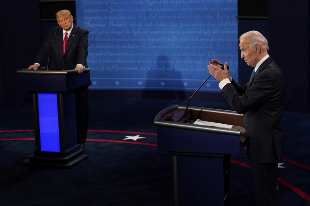 FILE - Democratic presidential candidate former Vice President Joe Biden answers a question as President Donald Trump listens during the second and final presidential debate Oct. 22, 2020, at Belmont University in Nashville, Tenn. The two front-runners for their party's nominations, former President Donald Trump and President Joe Biden, are barely campaigning in crucial early voting states as the primary season enters the fall rush.