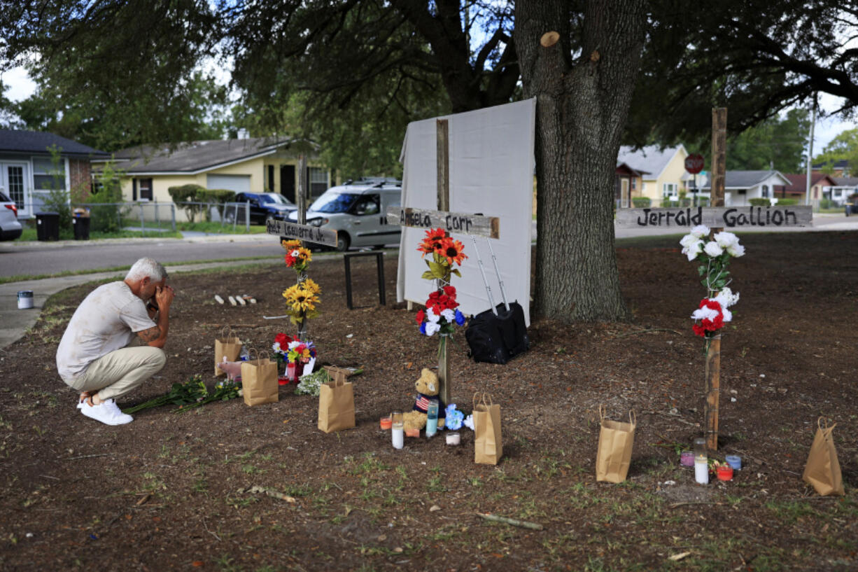Will Walsh, of Nocatee, Fla., prays in front of three crosses honoring the victims of Saturday's shooting near the site of the attack at a Dollar General store in Jacksonville, Fla., Monday, Aug. 28, 2023.