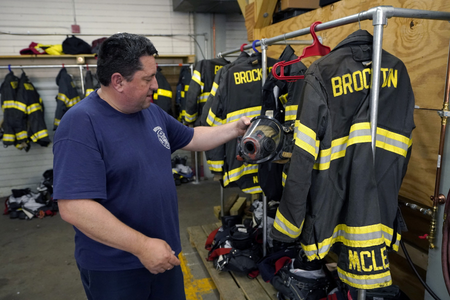 Firefighter William Hill of Brockton, Mass., displays protective gear at Station 1 on Aug. 3 in Brockton, Mass. Firefighters around the country are concerned that gear laced with the toxic compound PFAS could be one reason why cancer rates among their ranks are rising.