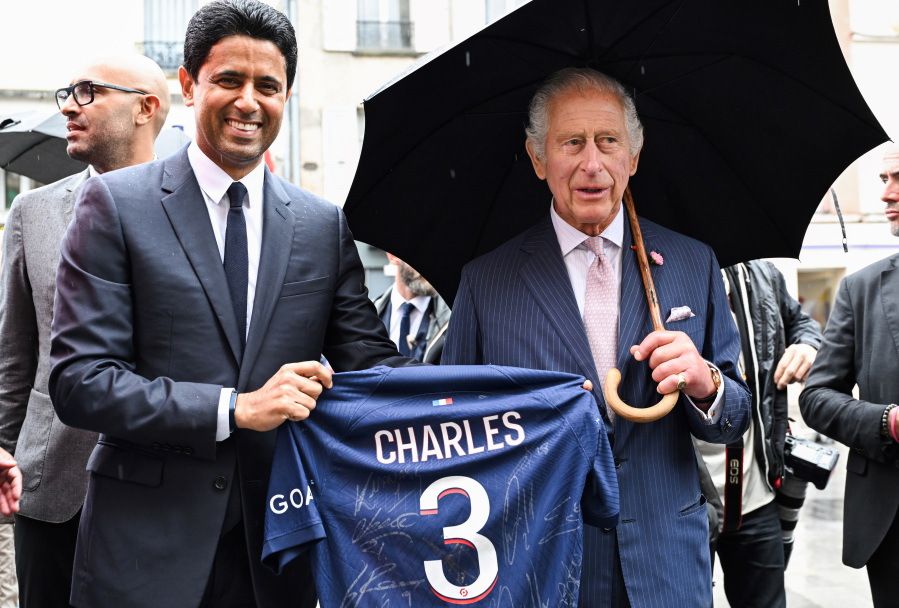 Paris Saint Germain's president Nasser Al-Khelaifi offers Britain's King Charles III a PSG jersey, Thursday, Sept. 21, 2023 in Saint-Denis, outside Paris. On the second day of his state visit to France, King Charles met with sports groups in the northern suburbs of Paris and was scheduled to pay a visit to fire-damaged Notre-Dame cathedral.