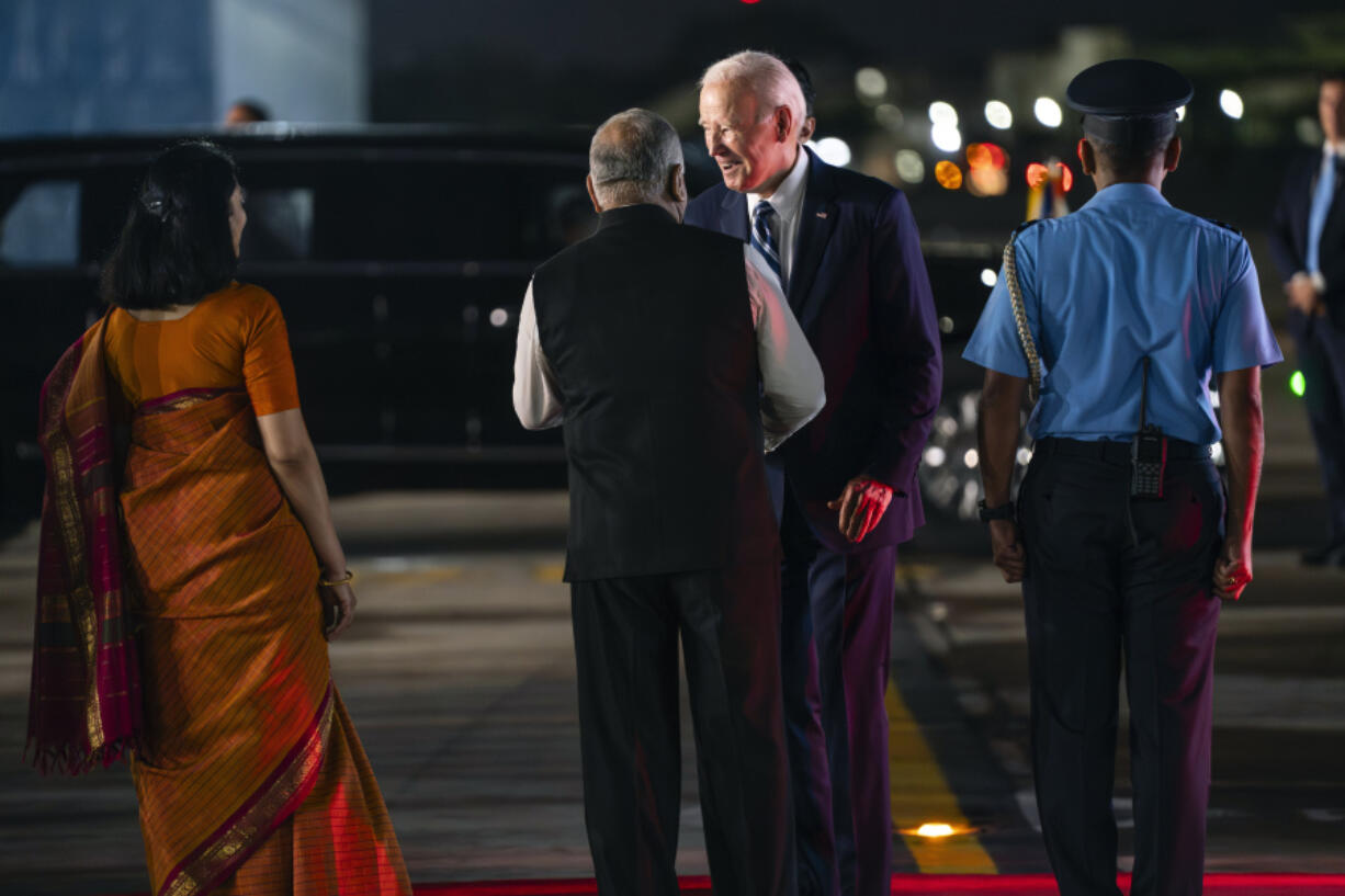 President Joe Biden greets , Vijay Kumar Singh, Minister of State for Road Transport and Highways & Minister of State for Civil Aviation, as Air Commodore AS Parandekar, Commanding Air Officer, right, watches, as Biden arrives at Indira Gandhi International Airport to attend the G20 summit, Friday, Sept. 8, 2023, in New Delhi. At left is Vani Sarraju Rao, Joint Secretary in the Ministry of External Affairs.