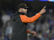 San Francisco Giants manager Gabe Kapler points to the bullpen, calling for relief pitcher Camilo Doval during the eighth inning of the team's baseball game against the Los Angeles Dodgers in Los Angeles, Friday, Sept. 22, 2023.
