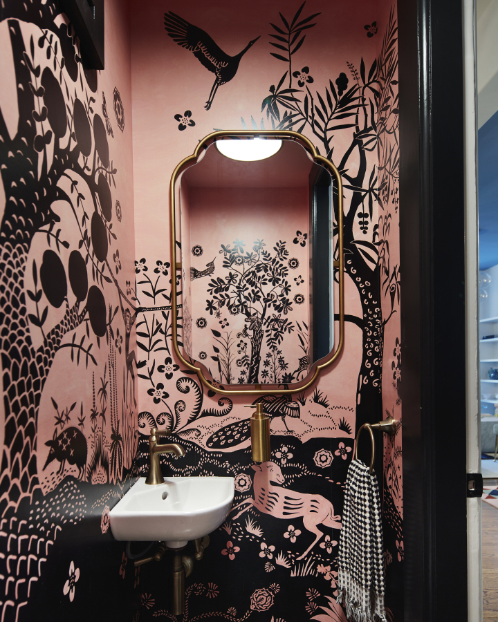 San Francisco-based designer Emilie Munroe, owner of Studio Munroe, created a tiny powder room of a family's Victorian home with an exuberant pink and black animal print wallpaper.