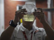 Edgard Boqu?n, a project leader working with Doctors Without Borders, holds a glass jar filled with mosquitoes before their release in neighborhoods rife with dengue, in a facility in Tegucigalpa, Honduras, Tuesday, Aug. 22, 2023. The mosquitoes come from eggs, produced in a World Mosquito Program bio factory to carry the bacteria Wolbachia, which interrupts the transmission of dengue.