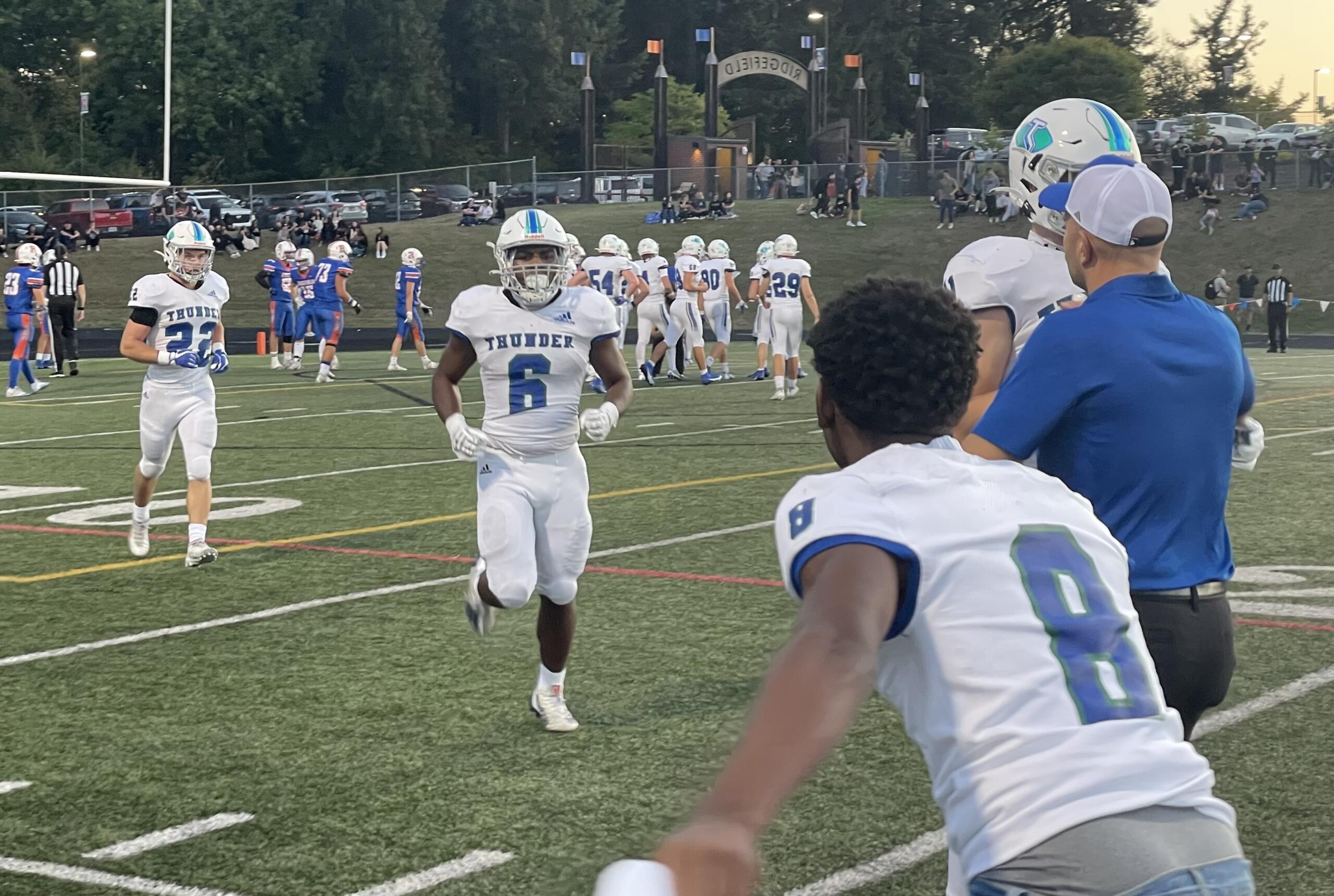 Mountain View players and coaches greet Jaden Brown (6) after the junior running back scored a 52-yard touchdown  against Ridgefield on Friday, Sept. 8, 2023, at Ridgefield High School.