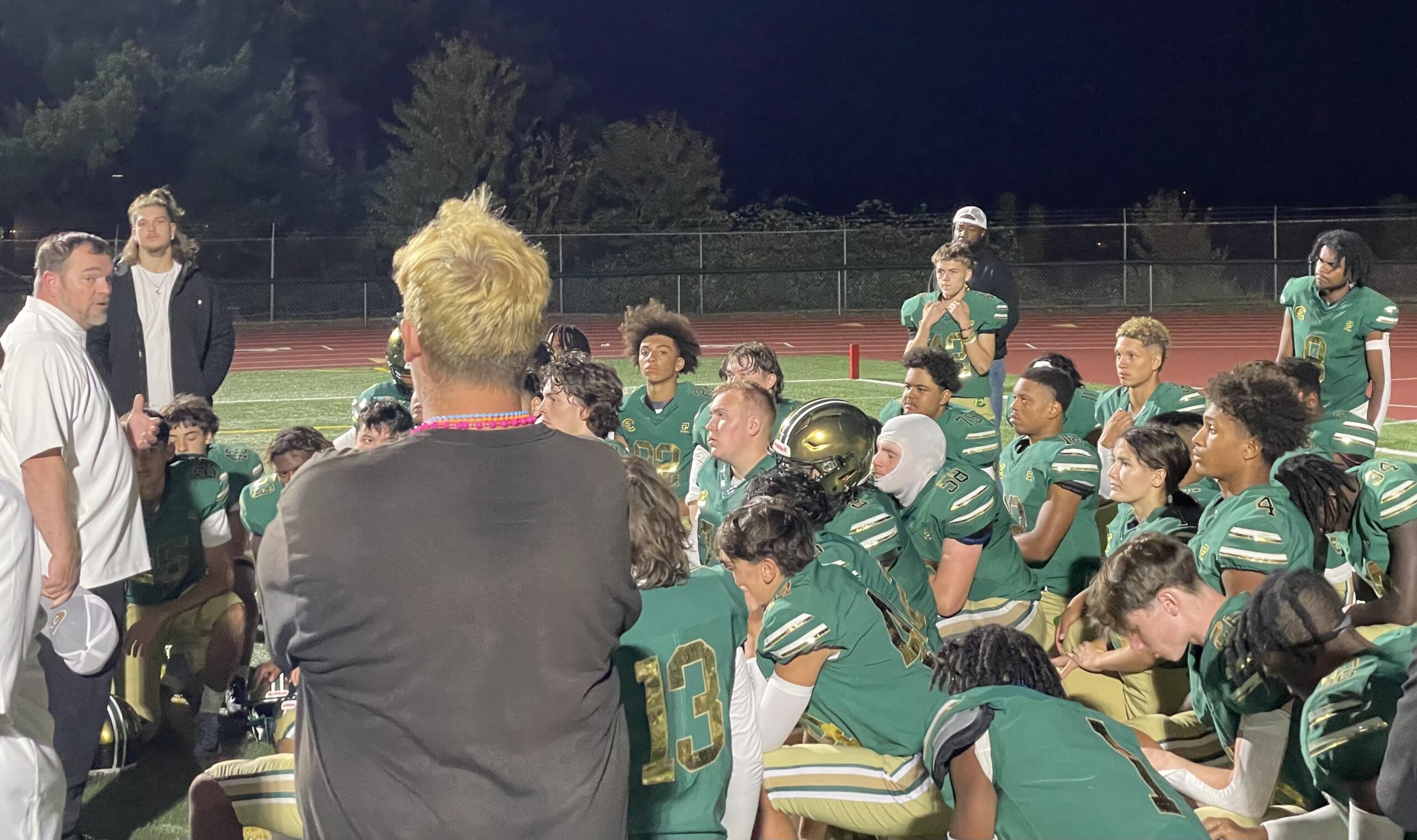 Evergreen coach Christian Swain, left, talks to his team after the Plainsmen fell to Glacier Peak, 21-0, on Friday, Sept. 22, 2023, at McKenzie Stadium.
