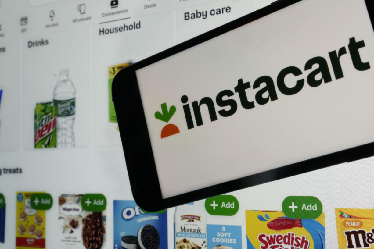 An instacart logo and an instacart webpage are shown in this photo, in New York, Wednesday, Sept. 6, 2023.