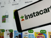An instacart logo and an instacart webpage are shown in this photo, in New York, Wednesday, Sept. 6, 2023.