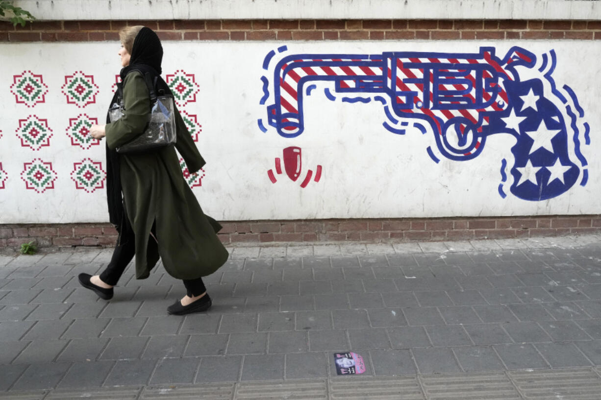 A woman walks past an anti-U.S. mural painted on the wall of the former U.S. Embassy in Tehran, Iran, on Aug. 19, 2023.