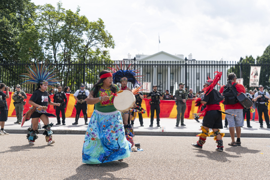 People sing and dance in front of police during a rally outside of the White House in support of imprisoned Native American activist Leonard Peltier, Tuesday, Sept. 12, 2023, in Washington.