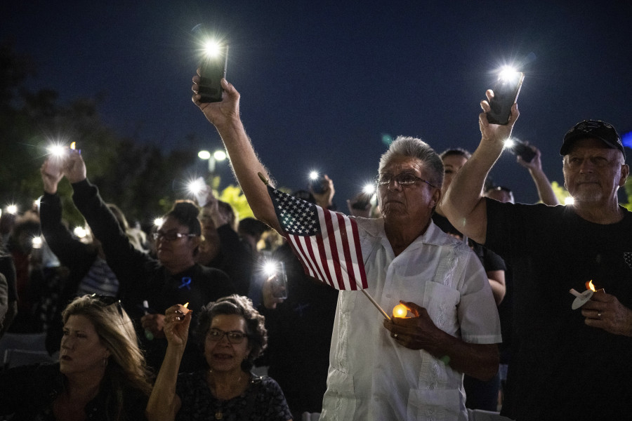 Miguel Ruiz, center, and his wife, Sara, seated, attend a vigil in Palmdale, Calif., for Los Angeles County Sheriff's Deputy Ryan Clinkunbroomer at the Palmdale Sheriff's Station, Sunday, Sept. 17, 2023, after the training officer was shot and killed in his patrol car at an intersection a day earlier. The Ruiz's son is a deputy at the Palmdale station.