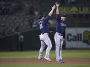 Seattle Mariners first baseman Ty France, left, and third baseman Eugenio Suárez celebrate the team's 7-2 victory over the against the Oakland Athletics in a baseball game Tuesday, Sept. 19, 2023, in Oakland, Calif. (AP Photo/Godofredo A.