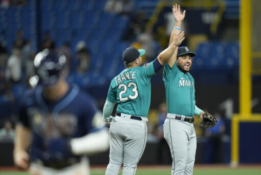 Seattle Mariners third baseman Eugenio Suarez and first baseman Ty France (23) celebrate after the team defeated the Tampa Bay Rays during a baseball game Thursday, Sept. 7, 2023, in St. Petersburg, Fla.