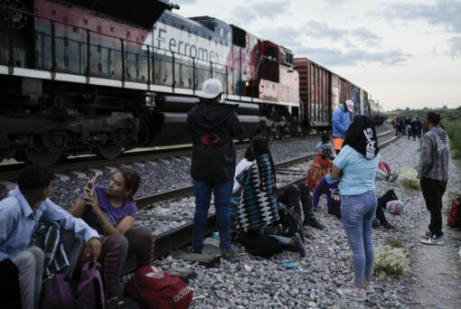 Migrants watch a train go past as they wait along the train tracks hoping to board a freight train heading north, in Huehuetoca, Mexico, Sept. 19, 2023. Ferromex, Mexico's largest railroad company announced that it was suspending operations of its cargo trains due to the massive number of migrants that are illegally hitching a ride on its trains moving north towards the U.S. border.
