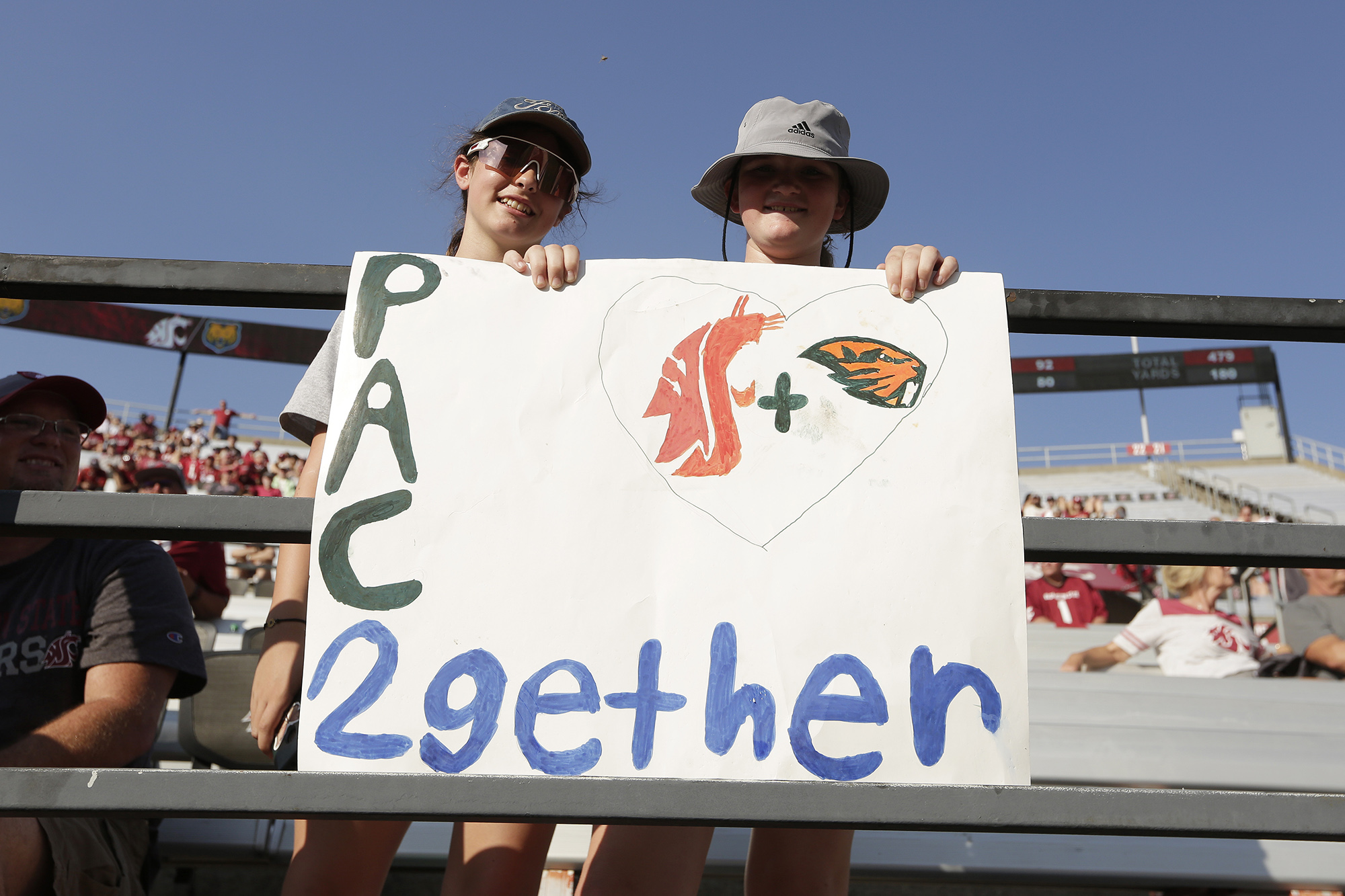 12-year-olds Izzy Aberill, left, and Josie Boyd hold a sign about Washington State and Oregon State being the only two schools left in the Pac-12 after the 2023-2024 academic year after the other schools in the conference announced plans to leave, during the second half of an NCAA college football game between Washington State and Northern Colorado, Saturday, Sept. 16, 2023, in Pullman, Wash. Washington State won 64-21.