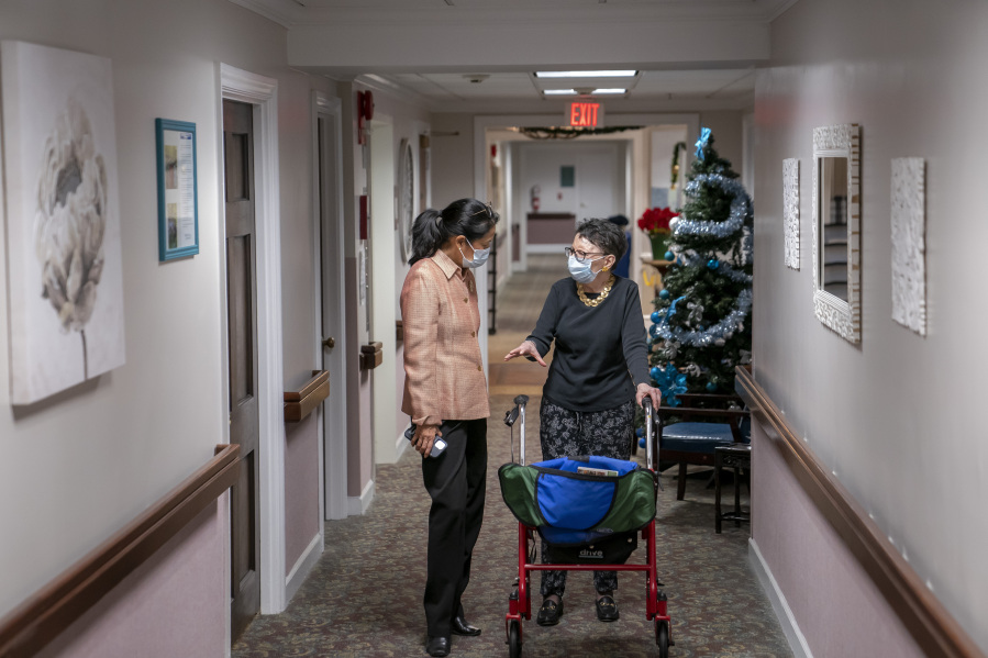 FILE - Tina Sandri, CEO of Forest Hills of DC senior living facility, left, helps resident Courty Andrews back to her room, Dec. 8, 2022, in Washington. The federal government will, for the first time, dictate staffing levels at nursing homes, the Biden administration said Friday, Sept. 1, 2023, responding to systemic problems bared by mass COVID deaths.