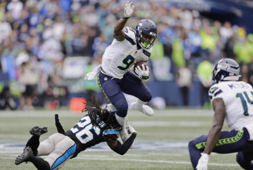Seattle Seahawks running back Kenneth Walker III is tackled by Carolina Panthers cornerback Donte Jackson during the second half of an NFL football game Sunday, Sept. 24, 2023, in Seattle.