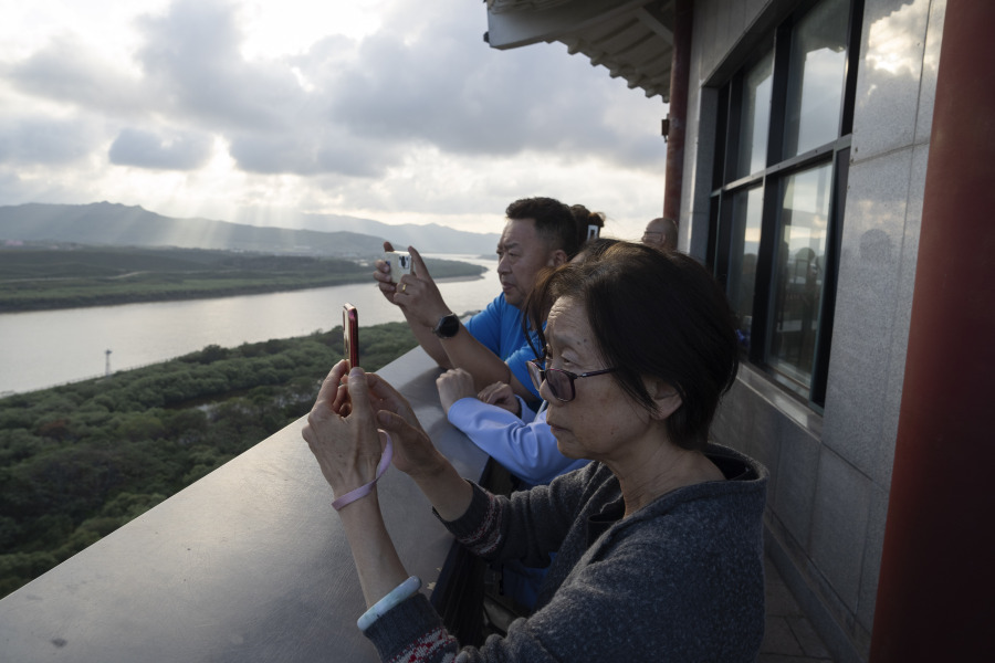 Visitors to the Yiyanwang Three Kingdoms viewing platform look over into the North Korean border across from Fangchuan in northeastern China's Jilin province on Monday, Sept. 11, 2023. Russia and North Korea confirmed Monday that North Korean leader Kim Jong Un will visit Russia in a highly anticipated meeting with President Vladimir Putin that has sparked Western concerns about a potential arms deal for Moscow's war in Ukraine.