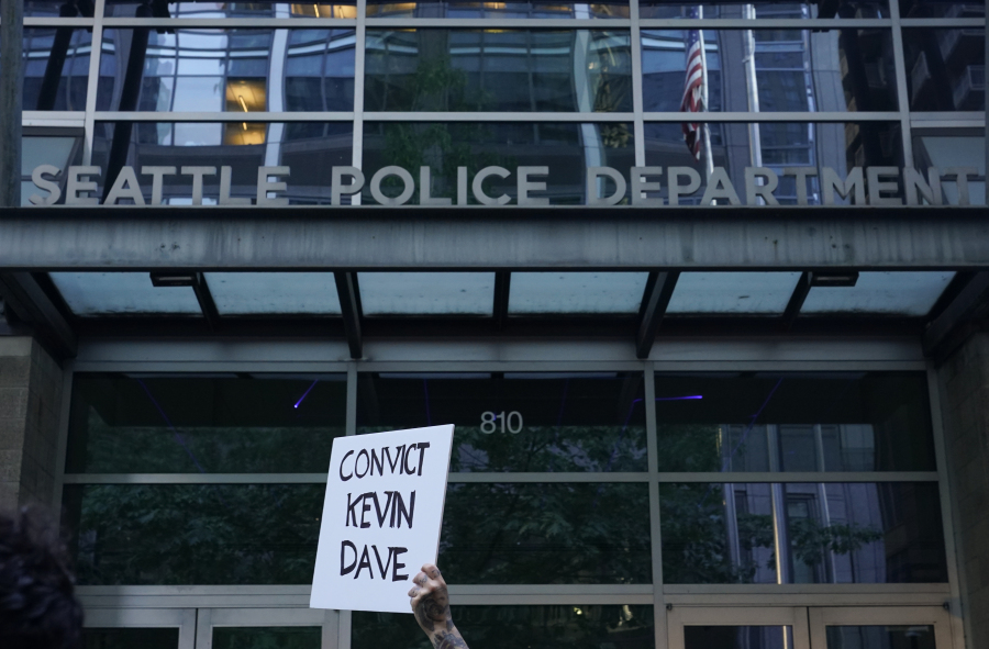 A protester holds a sign calling for the conviction of Seattle Police officer Kevin Dave, who hit and killed Jaahnavi Kandula while driving a police cruiser in January, as people protest after body camera footage was released of a Seattle police officer joking about Kandula's death, Thursday, Sept. 14, 2023, outside the Seattle Police Department's West Precinct in Seattle.