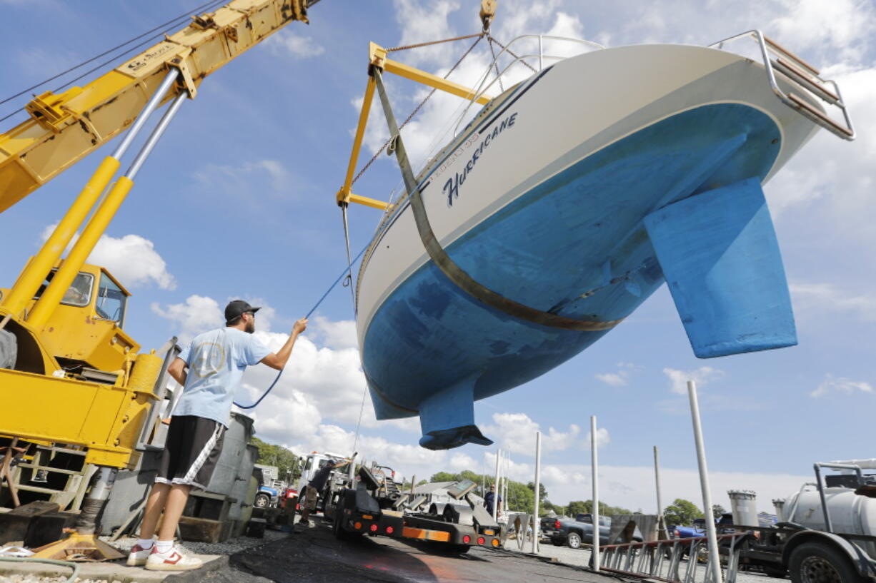 Davis & Tripp Marina and Boat Yard crews pull a sailboat named Hurricane from the waters of Padanaram Harbor in Dartmouth, Mass., Thursday, Sept. 14, 2023 in preparation for the possible arrival of Hurricane Lee.