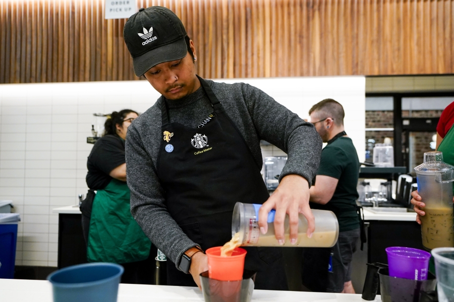 Tryer Lab partner Chan Chan pours a drink into a reusable personal cup during a test at the Tryer Center at Starbucks headquarters, Wednesday, June 28, 2023, in Seattle.