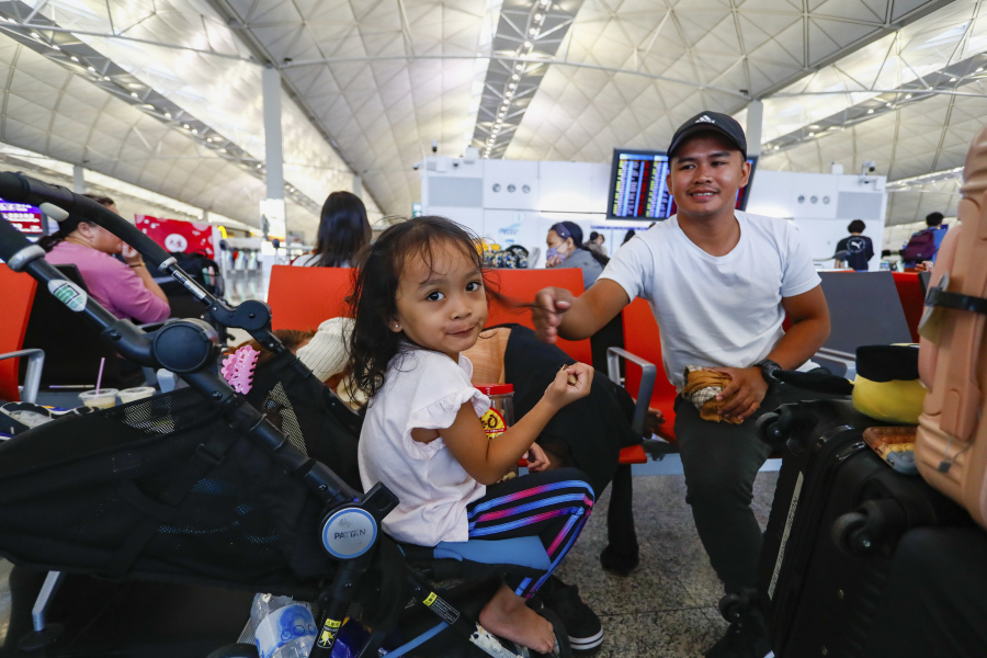 Filipino tourist Andres at right with his daughter wait for rescheduling after their flight returning to the Philippines was cancelled at the Hong Kong International Airport, in Hong Kong, on Friday, Sept. 1, 2023. Hundreds of flights were cancelled as most of Hong Kong and other parts of southern China ground to a near standstill as Super Typhoon Saola edged closer Friday.