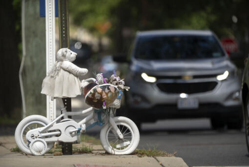 A vehicle drives past a memorial for 5-year-old Allie Hart, who was struck and killed in 2021 by a driver while riding her bicycle in a crosswalk, Monday, Sept. 11, 2023, in Washington.