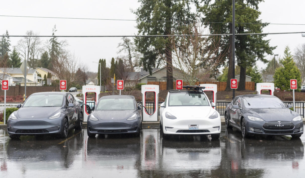 Teslas sit hooked up to electric chargers in December at Fred Meyer in Salmon Creek.