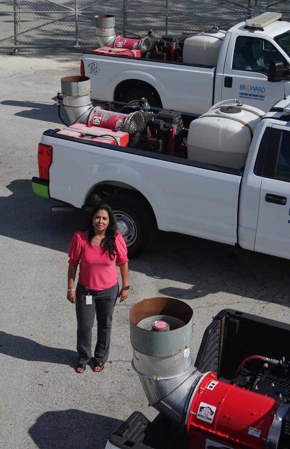 Adriana Toro is seen with three of the new mosquito control sprayers she helped invent Sept. 18,  in Pompano Beach, Fla. Officials expect the design to save the county money.