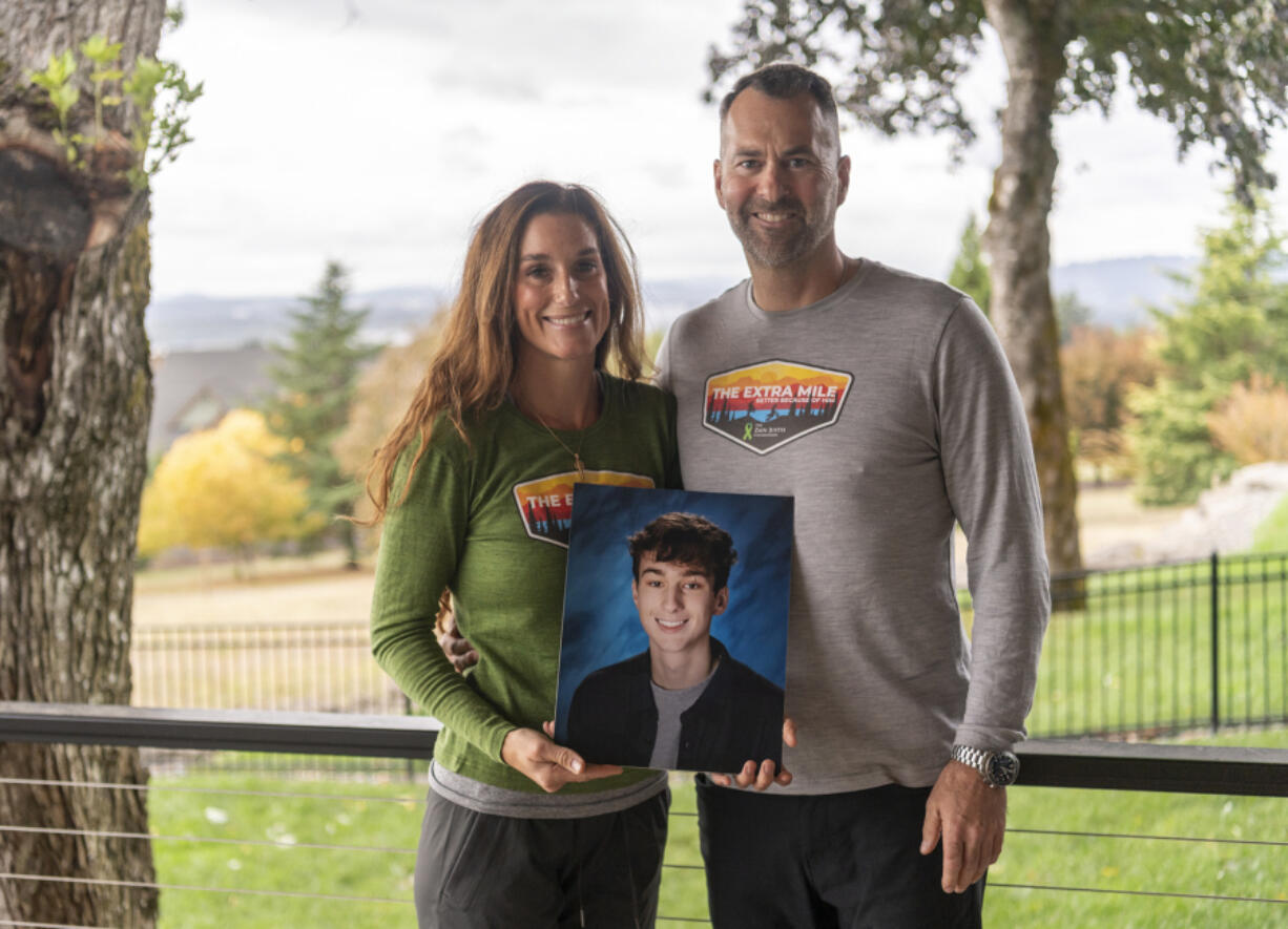 Linnea, left, and Matt Justis hold a photo of their son Zain Justis at their home in Washougal in late September. September is the month of childhood cancer awareness. Sept. 29 was the second anniversary of Zain's death.