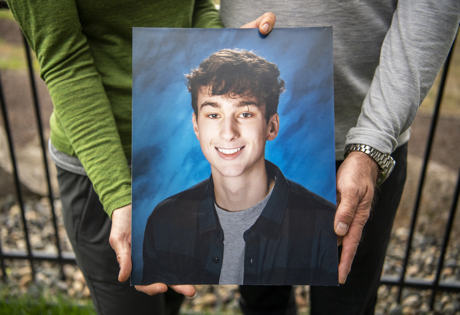 Linnea, left, and Matt Justis hold a photo of their son Zain Justis. Zain died in 2021 from primary mediastinal large B-cell lymphoma and his parents created the foundation to raise awareness of and fund research for rare types of cancer that affect kids and young adults.