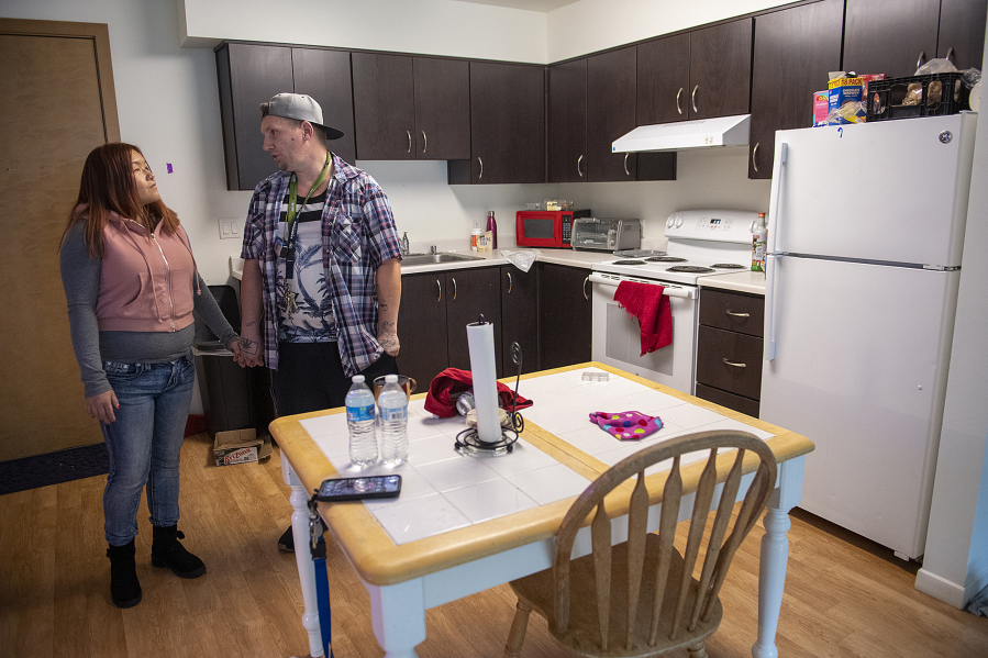 Katie Vongthongthip, left, and Chance Newbill talk in the kitchen in their new apartment.