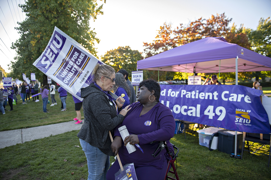 Judy Brunskill, left, registration representative for Kaiser Permanente, pauses to talk with longtime colleague Brenda Horey, a release of information specialist, as fellow workers strike in front of the Cascade Park Medical Office on the strike's third and final day. Horey, who is dealing with a leg injury and is battling breast cancer, has worked with Brunskill since 1986.